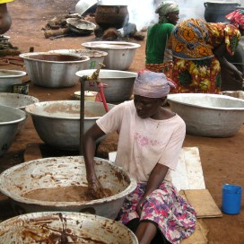 Members of a women’s cooperative in Tamale work in groups on the long process of extracting shea butter, an ingredient used in cosmetics and food production.